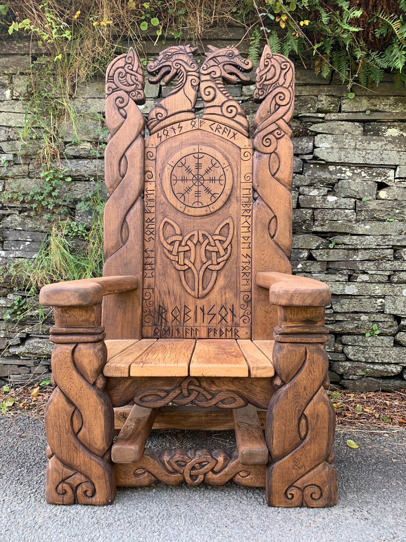 Viking chair with Celtic knotwork against stone wall