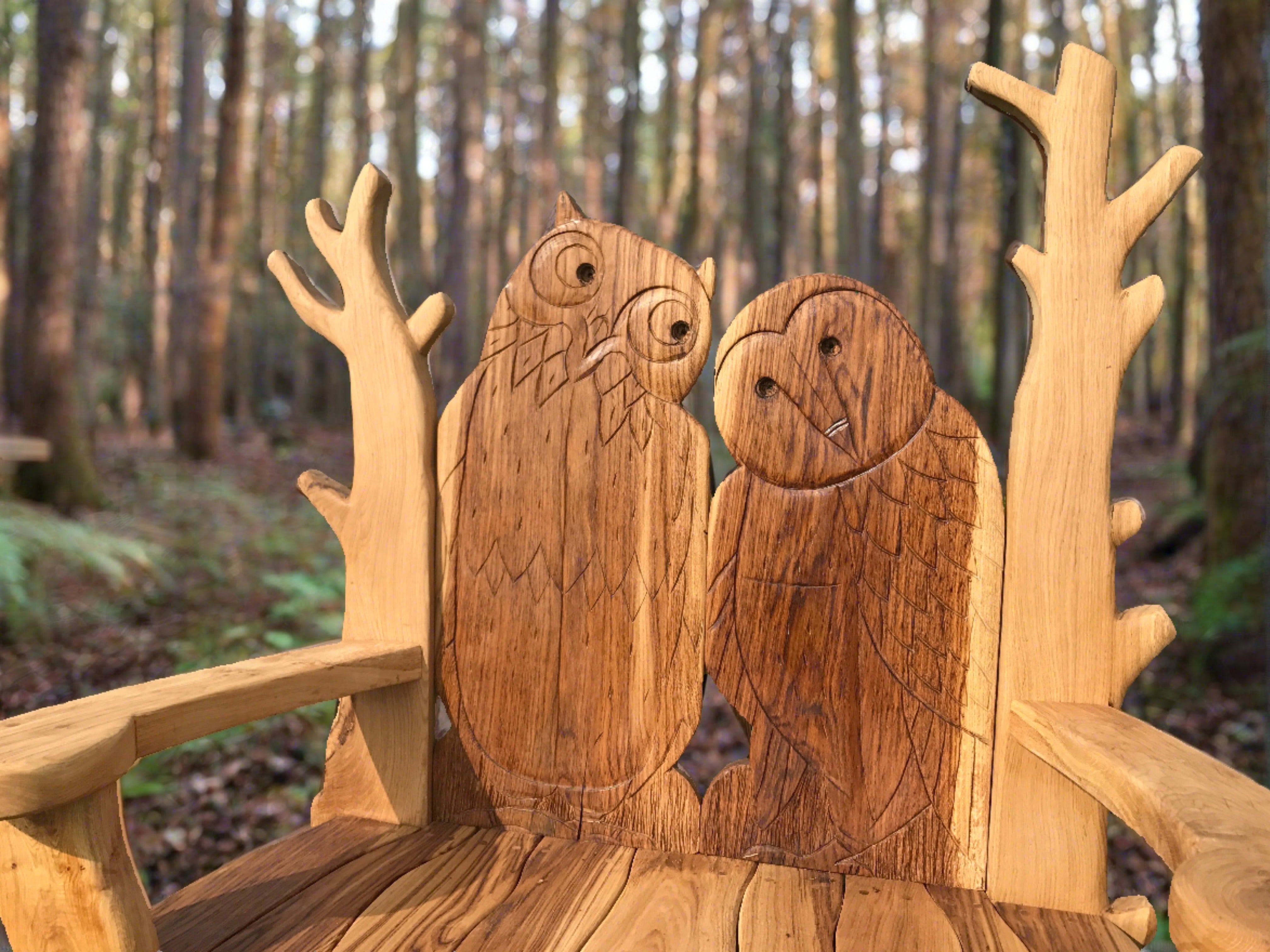 Detailed owl carvings on wooden bench in woods