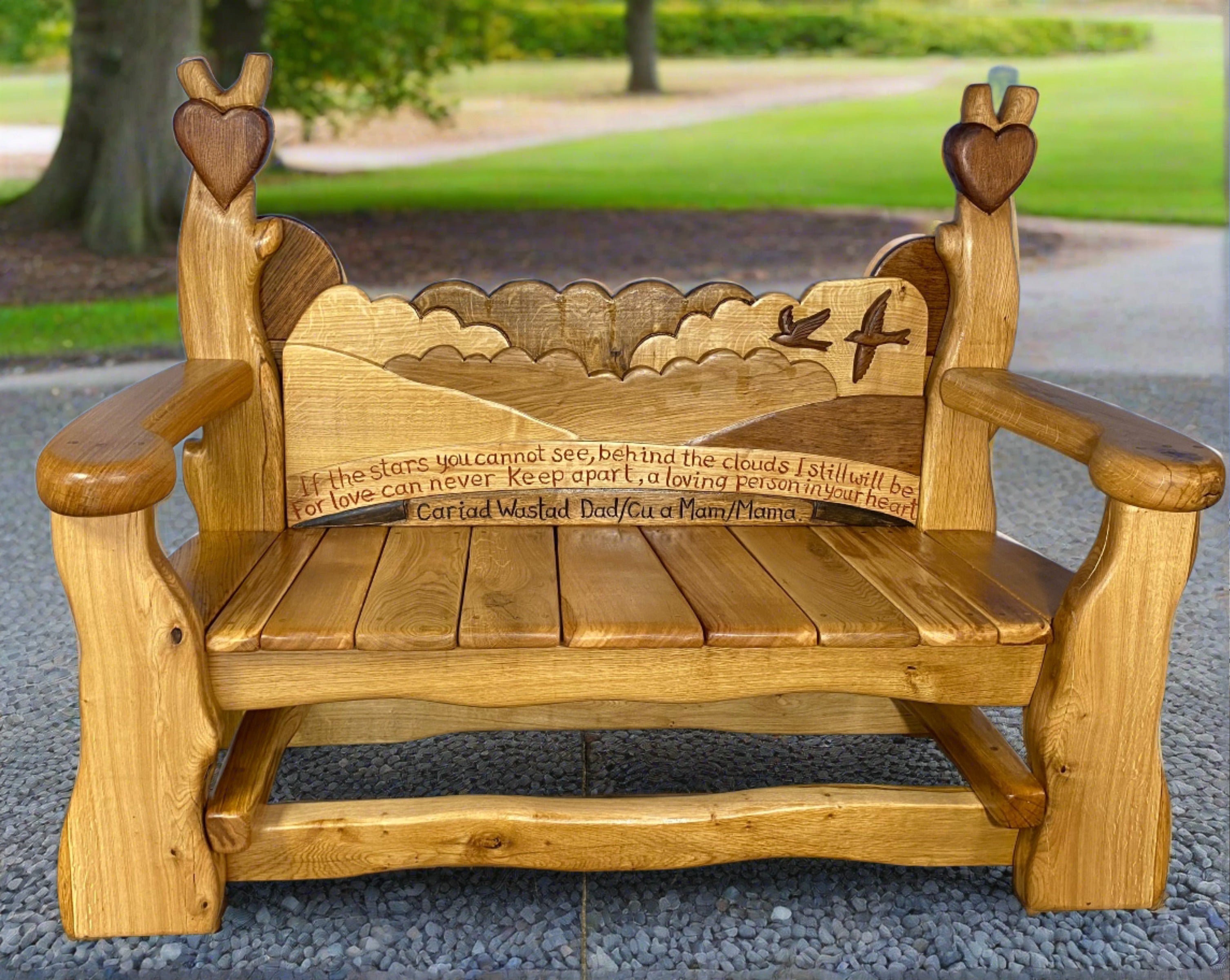 Memorial bench with heart and bird carvings