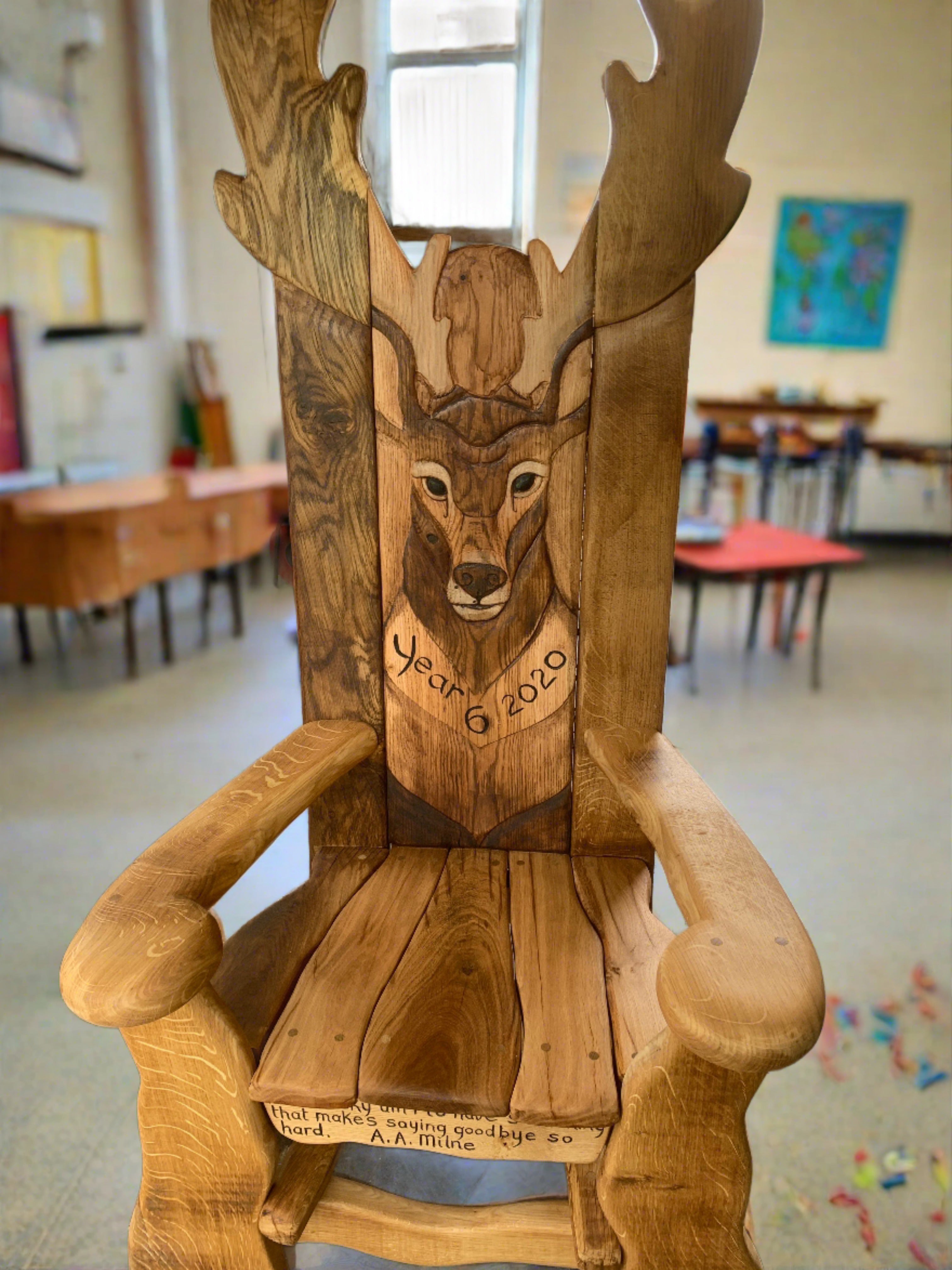 Wooden chair with deer carving in a classroom.