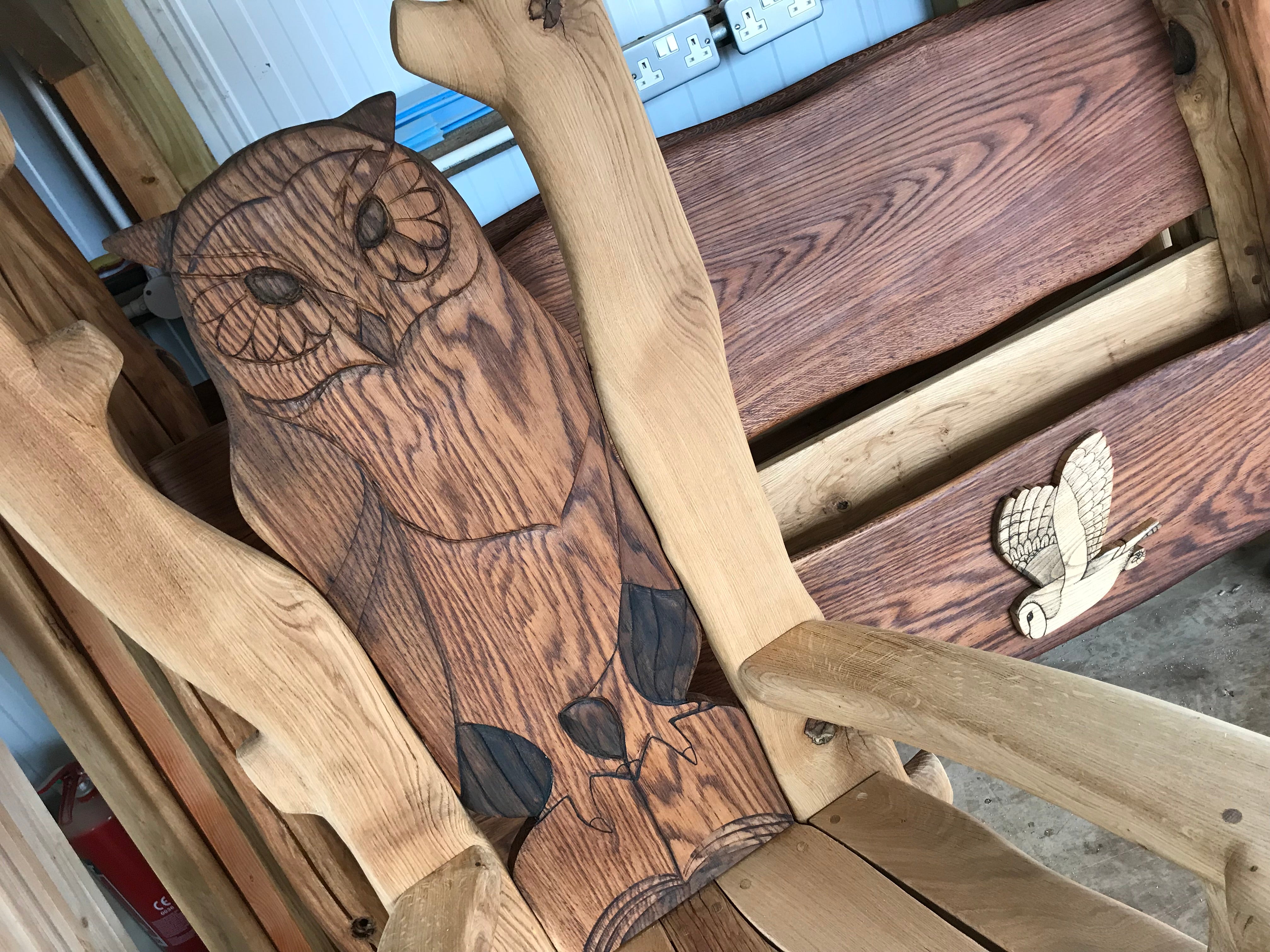 Carved owl on a wooden chair in a workshop.