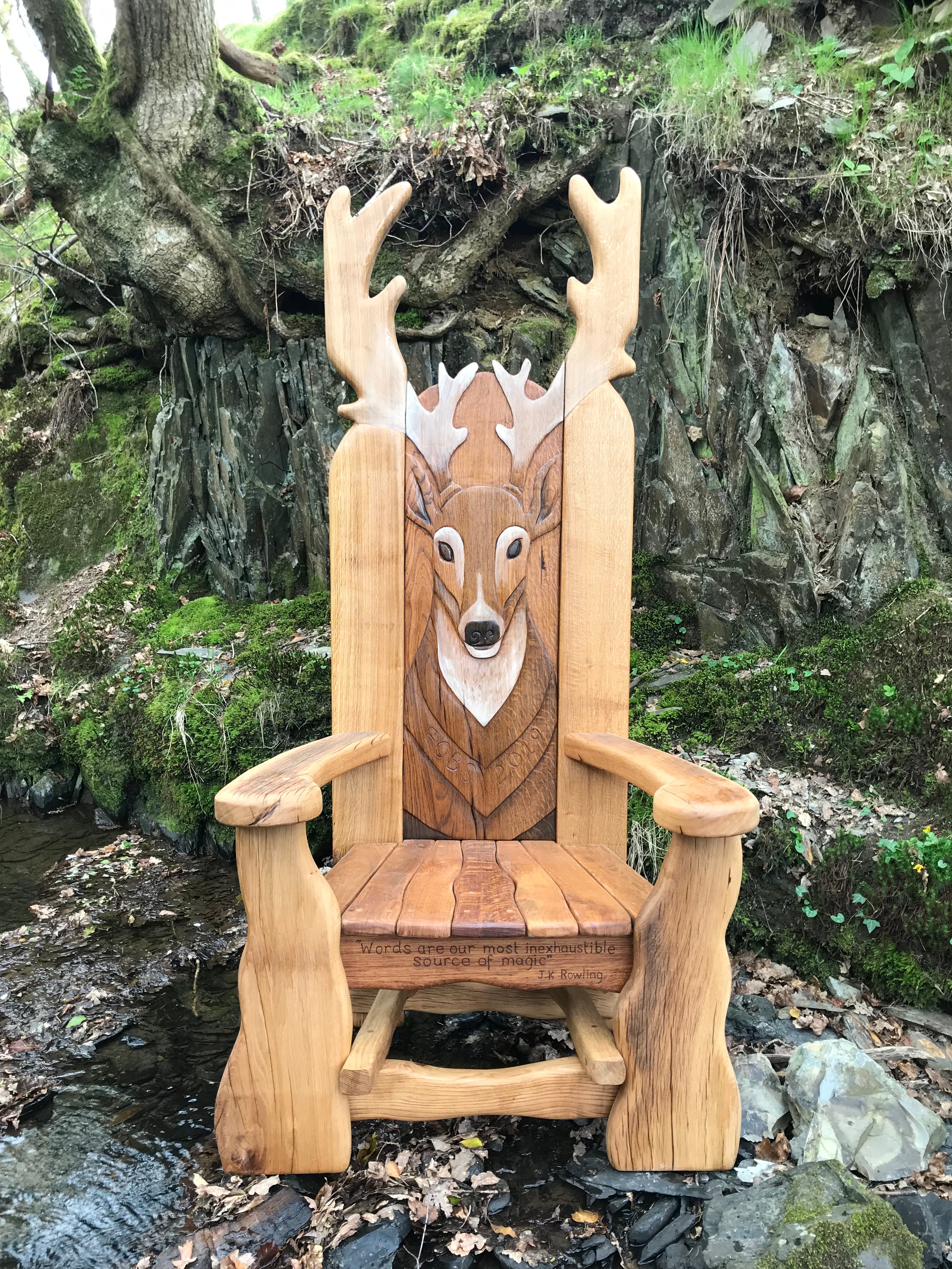 Wooden chair with carved deer in forest