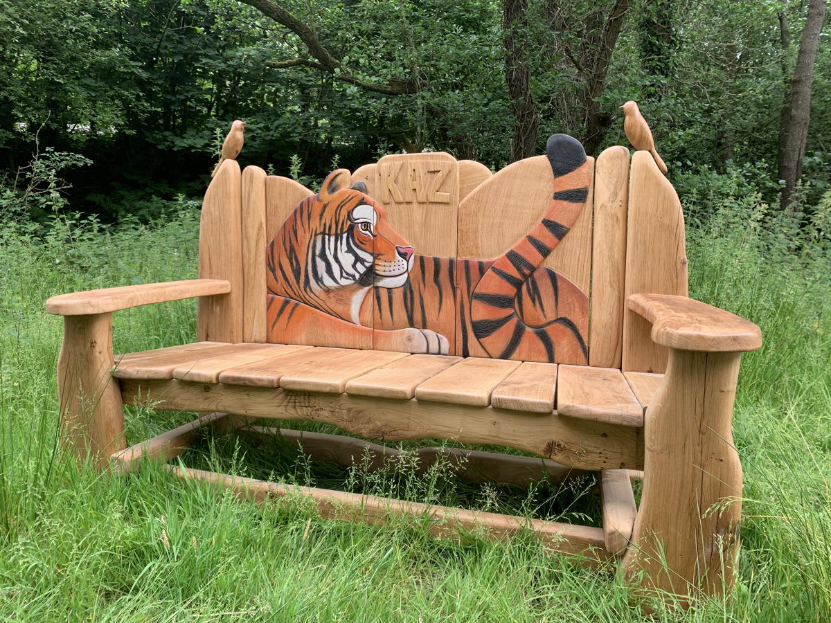 Side view of wooden bench with tiger design in a forest