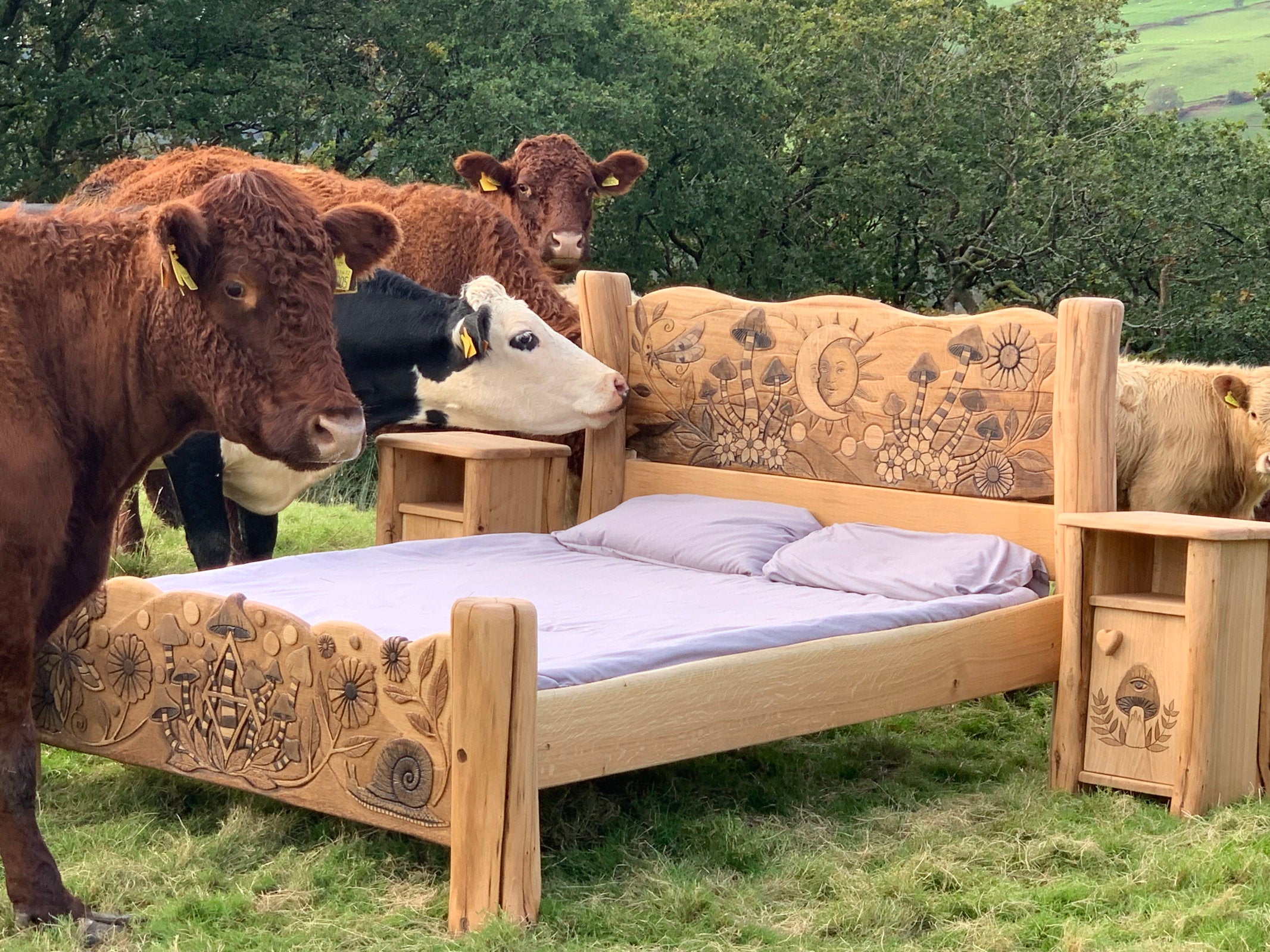 Oak bed with carved designs surrounded by cows