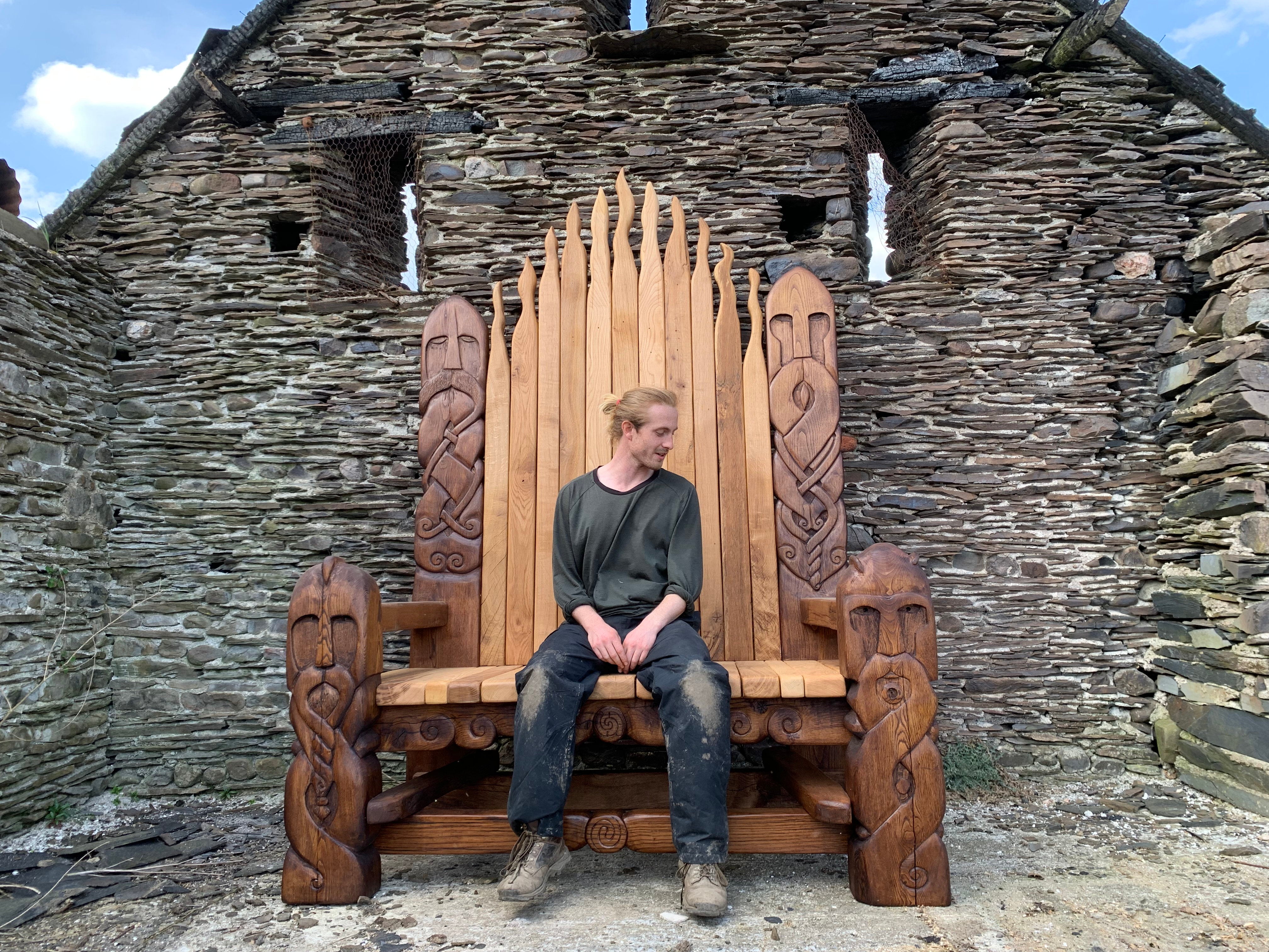 Carved Viking Throne in front of a welsh slate wall.