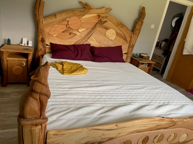 A close-up of the intricate wood carvings on the handcrafted sunrise bed and night tables