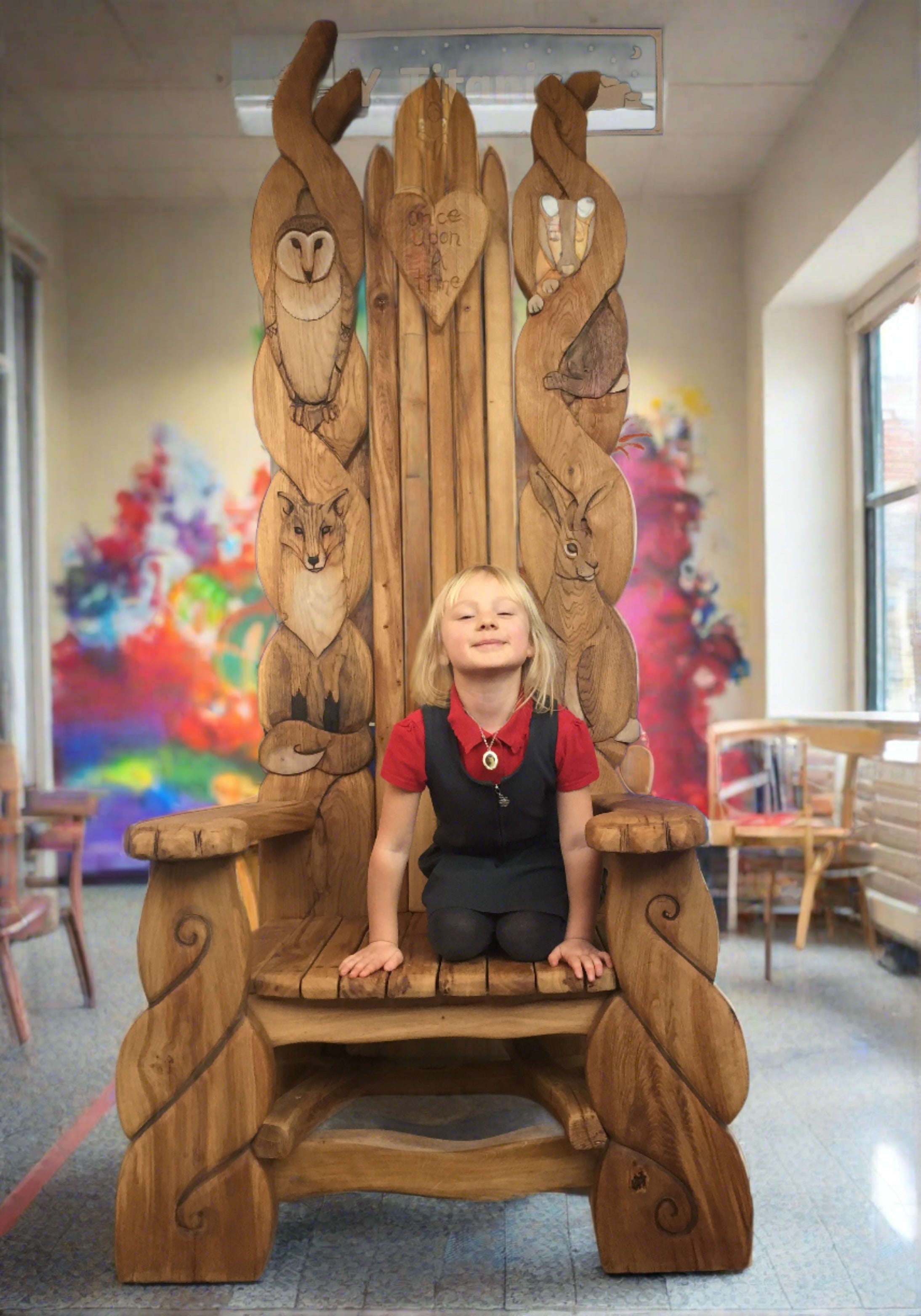 Large wooden chair with animal carvings in a classroom.