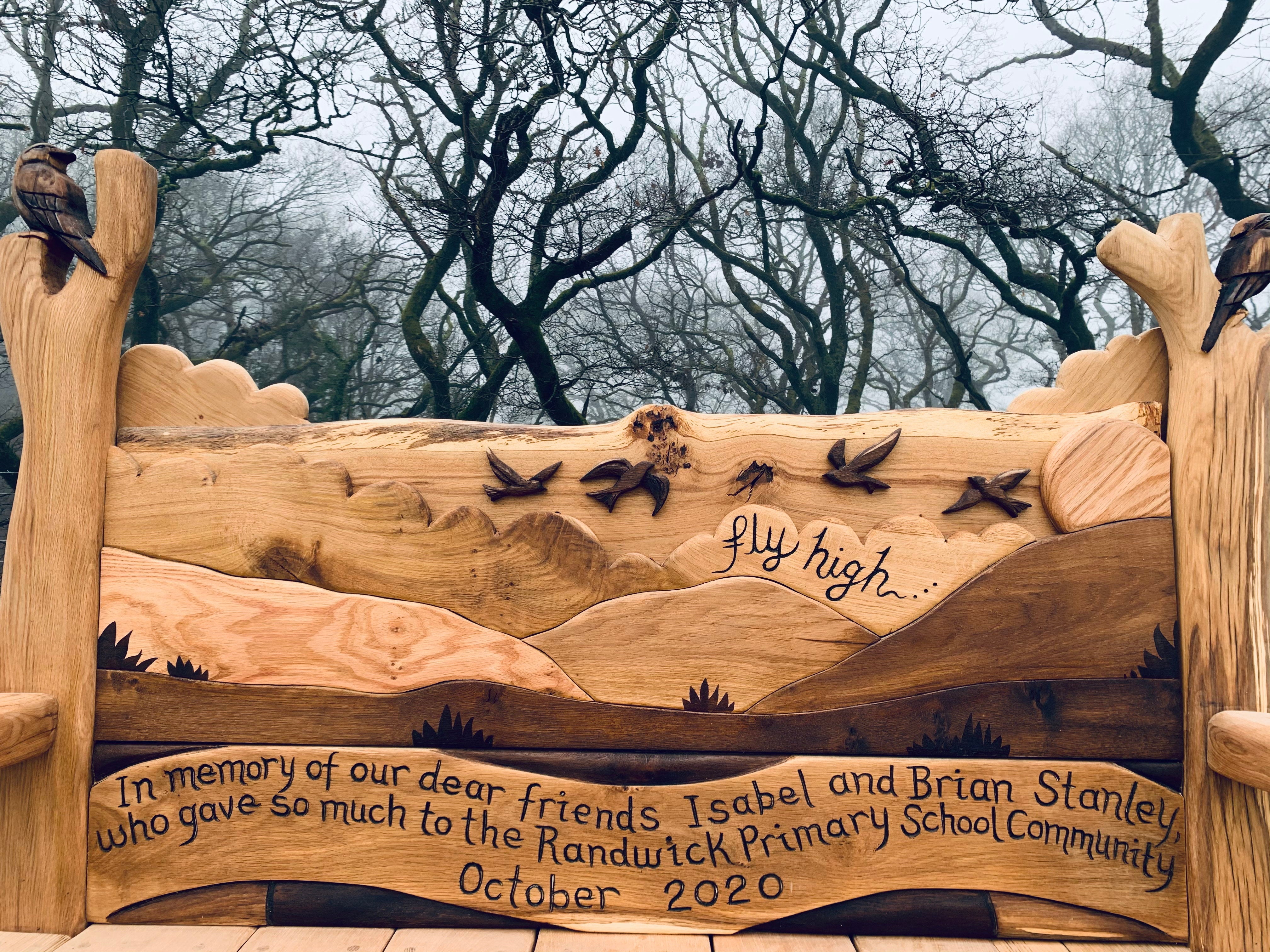 Close-up of bird carvings on memorial bench