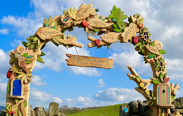 Whimsical wooden archway with nature and fairy elements