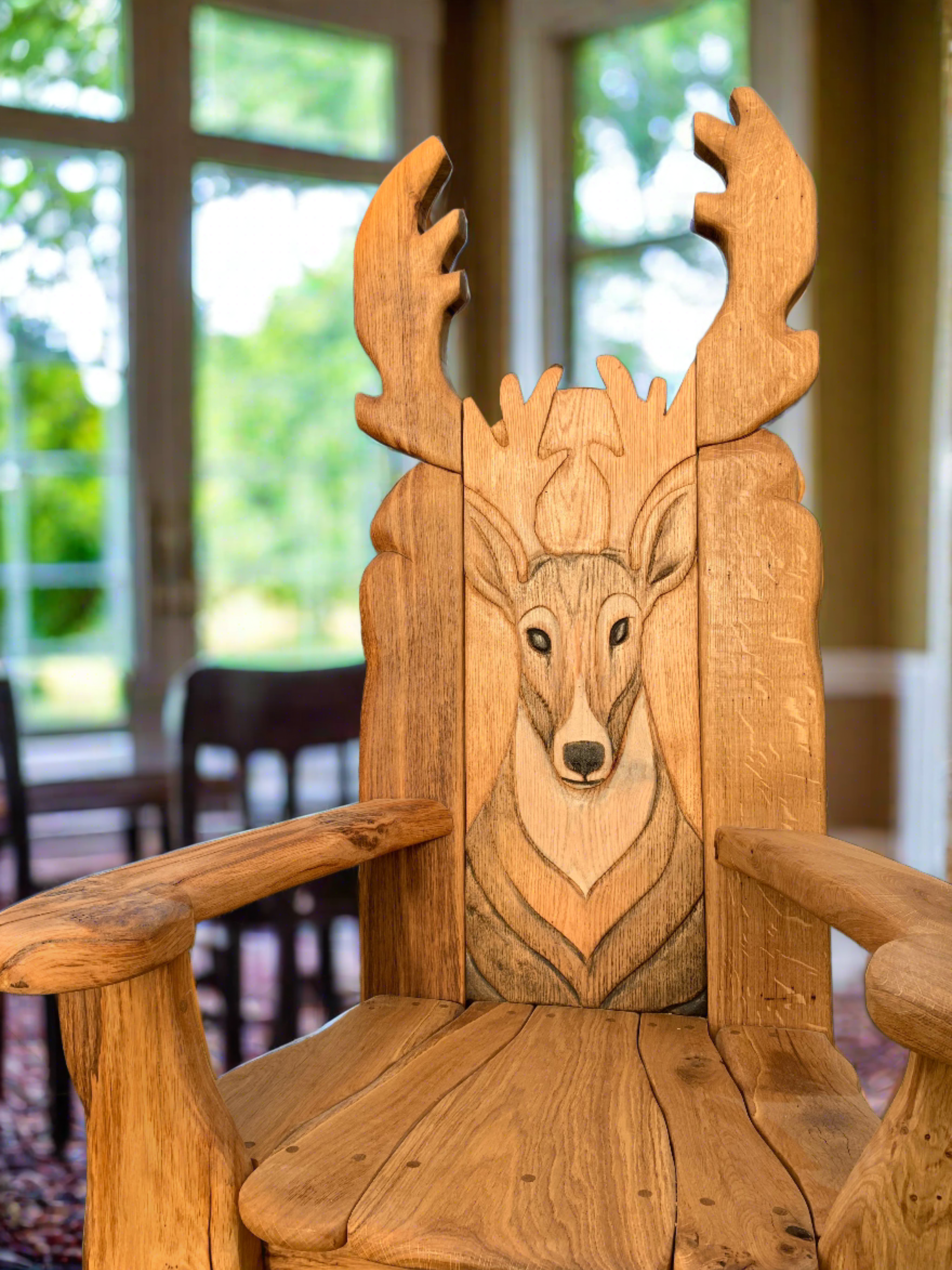 Wooden chair with deer carving in a sunlit room.