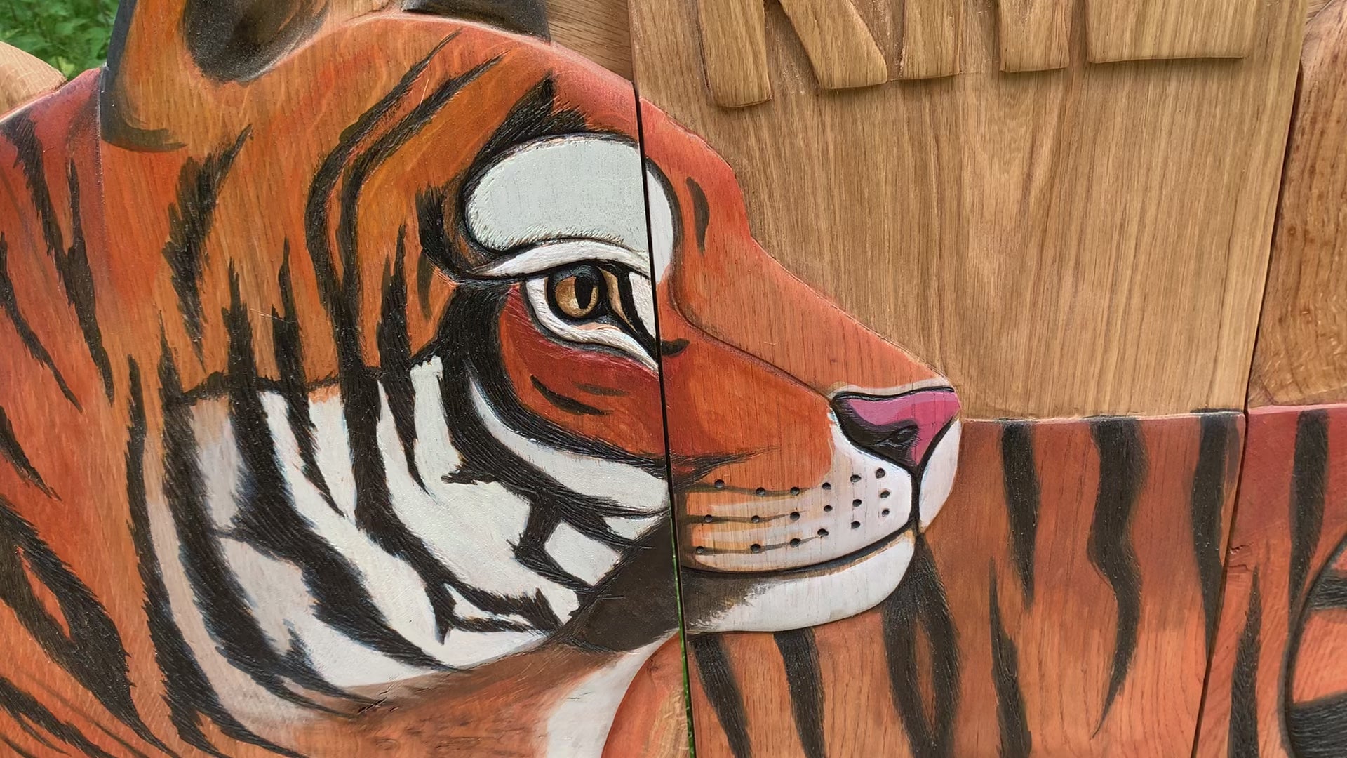 Detailed tiger face carving on a wooden bench